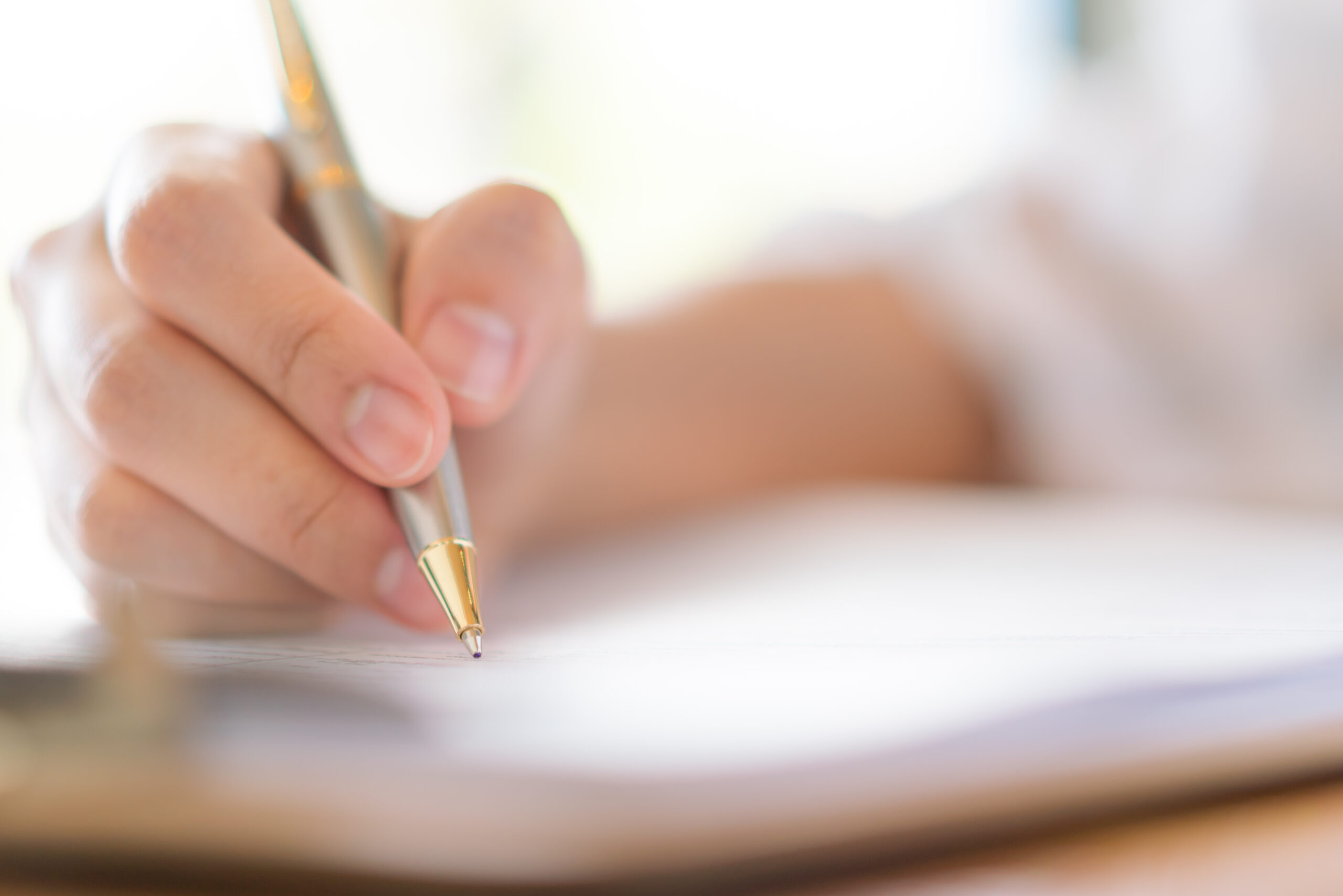Hand with pen over application form